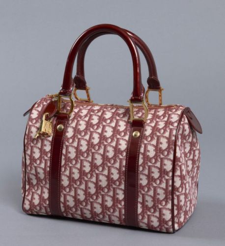 DIOR, Sac à main en toile monogrammée prune, finitions en cuir verni prune, garnitures en métal doré siglé, avec cadenas et clés. Intérieur en nylon, une poche zippée, une à pression. Légère patine d'usage, très bon état. 20 x 25 cm.
