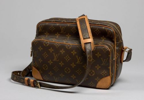 Louis VUITTON, Nil en toile Monogram, coins en cuir naturel, anse bandoulière assortie, grande poche sur le devant. 20 x 30 cm. Excellent état.