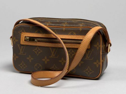 Louis VUITTON, Pochette Cite en toile Monogram, garnitures en cuir naturel. 12 x 21 cm. Excellent état.