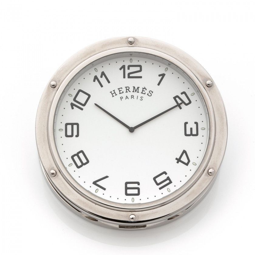 HERMÈS,Clipper, ref.PE-CL1705, n° 2142322,Vers 2000,Pendulette de voyage en métal chromé,Boîtier: rond sur charnière, signé,Cadran: blanc, chiffres arabes, signé,Mouvement: quartz,Diam.: 7,5 cm,A steel quartz travel clock,RAPPORT DE CONDITION,A la rédacti