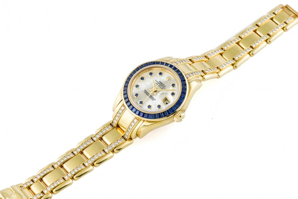 ROLEX DATEJUST LADY'S REF. 69308 YELLOW GOLD AND SAPPHIRES Very fine and rare, self-winding, 18K yellow gold lady's sapphire-set wristwatch with date and sapphire-set mother-of-pearl dial.