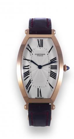 Tonneau Cintr_e.Cartier Paris, Tonneau Cintr_e, No. 0015, Ref..2458C. Sold on April 28, 2000..Fine, tonneau-shaped, curved, 18K pink gold wristwatch with.an 18K pink gold Cartier deployant clasp. Accompanied by a.fitted Cartier box, certificate, and bookl
