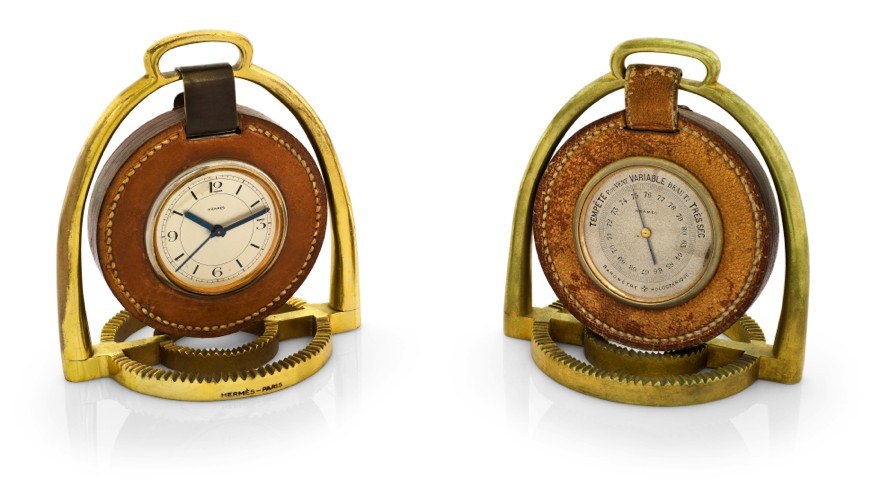 HERMÈS PENDULETTE & BAROMETER ÉTRIER.Hermès, Paris, Etrier, the movement by Pontifa-Audoine, Swiss. Made circa 1935..Fine and rare, 8-day going, gilt brass and leather stirrup-form desk clock with alarm and a matching aneroid barometer.Holosterique, proba