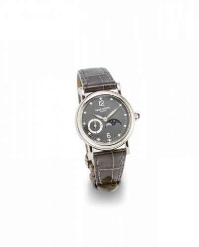 Patek Philippe. A lady's 18K white gold and diamond set manual wind wristwatch with moon phase with box and papers