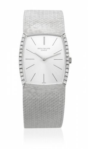 Patek Philippe. An 18K white gold and diamond set manual wind tonneau form bracelet watch