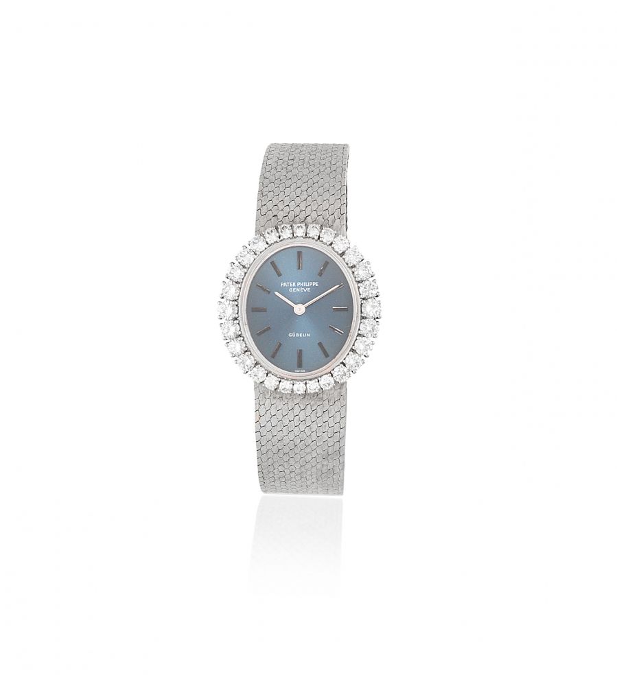 Patek Philippe. A lady's 18K white gold and diamond set manual wind bracelet watch retailed by Gübelin