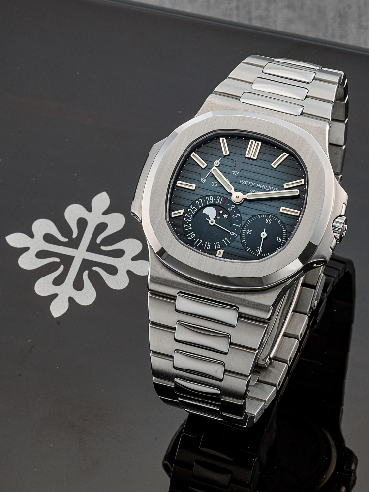 PATEK PHILIPPE | NAUTILUS - GENEVA SEAL, REF.5712/1A, A FINE LIKE-NEW STAINLESS STEEL BRACELET WATCH WITH MOON PHASES, POWER RESERVE INDICATOR AND DATE, CIRCA 2007