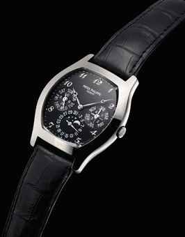PATEK PHILIPPE. A FINE 18K WHITE GOLD TONNEAU-SHAPED AUTOMATIC PERPETUAL CALENDAR WRISTWATCH WITH MOON PHASES, LEAP YEAR AND 24 HOUR INDICATION, BLACK DIAL, BREGUET NUMERALS, ORIGINAL CERTIFICATE, BOX AND ADDITIONAL CASE BACK
