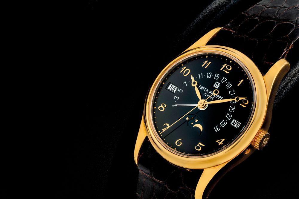 PATEK PHILIPPE. A VERY RARE 18K GOLD AUTOMATIC PERPETUAL CALENDAR WRISTWATCH WITH RETROGRADE DATE, LEAP YEAR INDICATION, MOON PHASES AND BLACK DIAL WITH BREGUET NUMERALS
