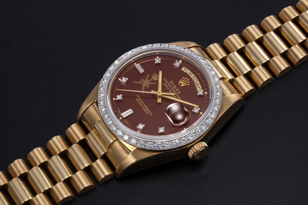 ROLEX, A GOLD AND DIAMOND-SET OYSTER PERPETUAL DAY-DATE WITH “KHANJAR” INSIGNIA ON THE OXBLOOD DIAL, REF. 18048 - CASE