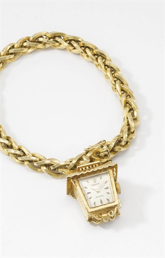 Rolex. An unusual 18K gold lantern-form bracelet watch with honeycomb dial