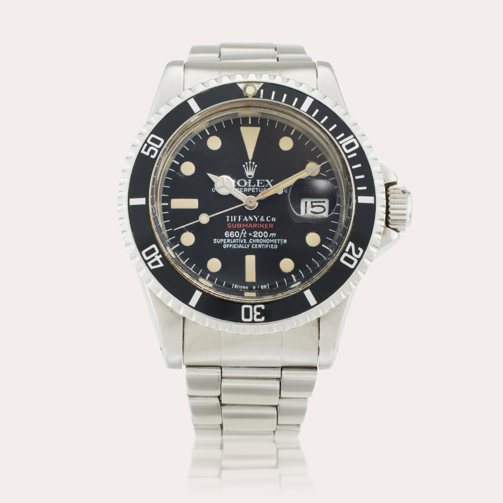 PROPERTY FROM THE FAMILY OF THE ORIGINAL OWNER Rolex Reference 1680 ‘Red’ Submariner | Retailed by Tiffany & Co.: A stainless steel automatic wristwatch with date and bracelet, Circa 1974